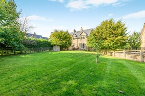 A well-maintained lawn with a stone building in the background. - 2 Bed in Chathill (oc-77990) (Ellingham)