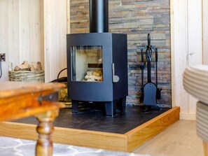 A wood-burning stove in a room with a stone wall and a wooden floor. - 2 Bed in Ludlow (oc-78024) (Richards Castle)