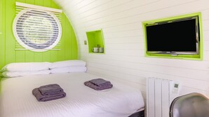 A room with a bed, a TV, a window with blinds, and a small shelf. - 1 Bed in Lampeter (oc-78189) (Lampeter)