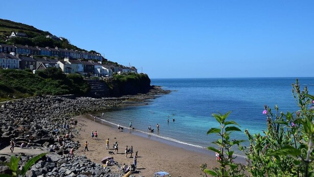 A coastal town with houses on a hillside, a rocky beach, and clear blue water. - 1 Bed in Lampeter (oc-78189) (Lampeter)