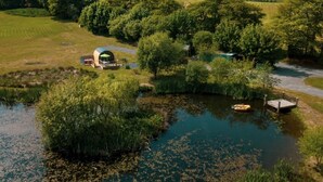 A riverside property with a circular building, a dock, and surrounding greenery. - 1 Bed in Lampeter (oc-78189) (Lampeter)