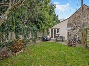 A stone building with a patio, a wooden fence, and a tree. - 2 Bed in Coleford (oc-78181) (English Bicknor)