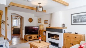 Ein Wohnzimmer mit Kamin, Fernseher und Holzmöbeln.
