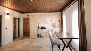 A kitchen with wooden cabinets, a dining table, and a bench.