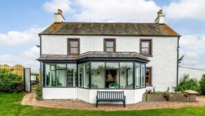 A two-story house with a bay window, a front bench, and a well-maintained lawn. - 3 Bed in Crieff (oc-78313) (Madderty)