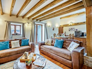A cozy living room with leather sofas, a coffee table with magazines, and a wooden ceiling. - 2 Bed in King's Lynn (oc-kt125) (Tattersett)