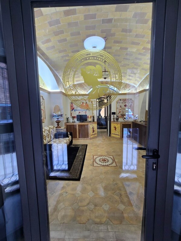 A room with a patterned floor, a chandelier, and a sofa. - The Etrurian Rapsody (Rome)