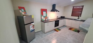 Eine kleine Küche mit Kühlschrank, Herd und Spüle.