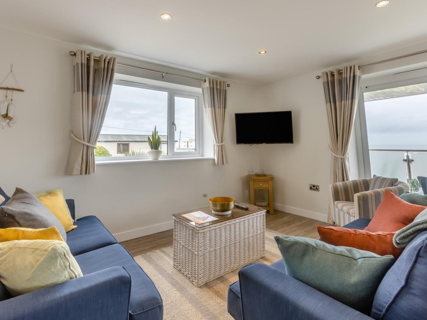 A living room with a sofa, a coffee table, a TV, and a window with curtains.