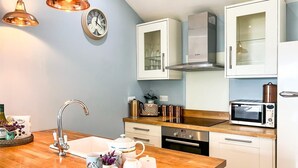 A modern kitchen with a wooden countertop, stainless steel appliances, and white cabinetry. - 2 Bed in Cinderford (oc-65670) (Littledean)