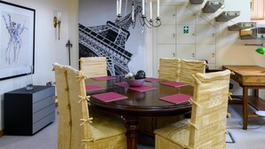 Una sala conferenze con un tavolo rotondo, sedie, un quadro e una scala.