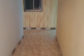 Ein Korridor mit einer Holztür und einem Fenster.