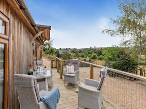 A wooden deck with wicker furniture, a table with a drink, and a view of a rural landscape. - 2 Bed in Leominster (oc-78637) (Stoke Prior)