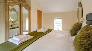 A hotel room with a large bed, two mirrors, a green runner, a lamp, and a door leading to a balcony. - 3 Bed in Matlock (oc-78717) (Crich)