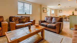 A living room with leather sofas, a wooden coffee table, and pendant lighting. - 3 Bed in Matlock (oc-78717) (Crich)