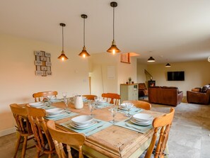 A dining area with a wooden table set for six, surrounded by chairs, with pendant lights above. - 3 Bed in Matlock (oc-78717) (Crich)