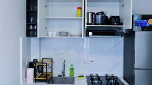 A modern kitchen with a gas stove, a coffee machine, and a built-in oven. - Beautiful and well furnished one bedroom apartment in a well secured area. (Nairobi)