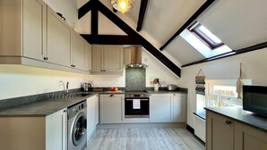 Cocina compacta con lavadora, horno y tragaluz.