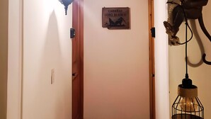 Un pasillo con techo de madera, un candelabro colgante y una cabeza de animal montada.