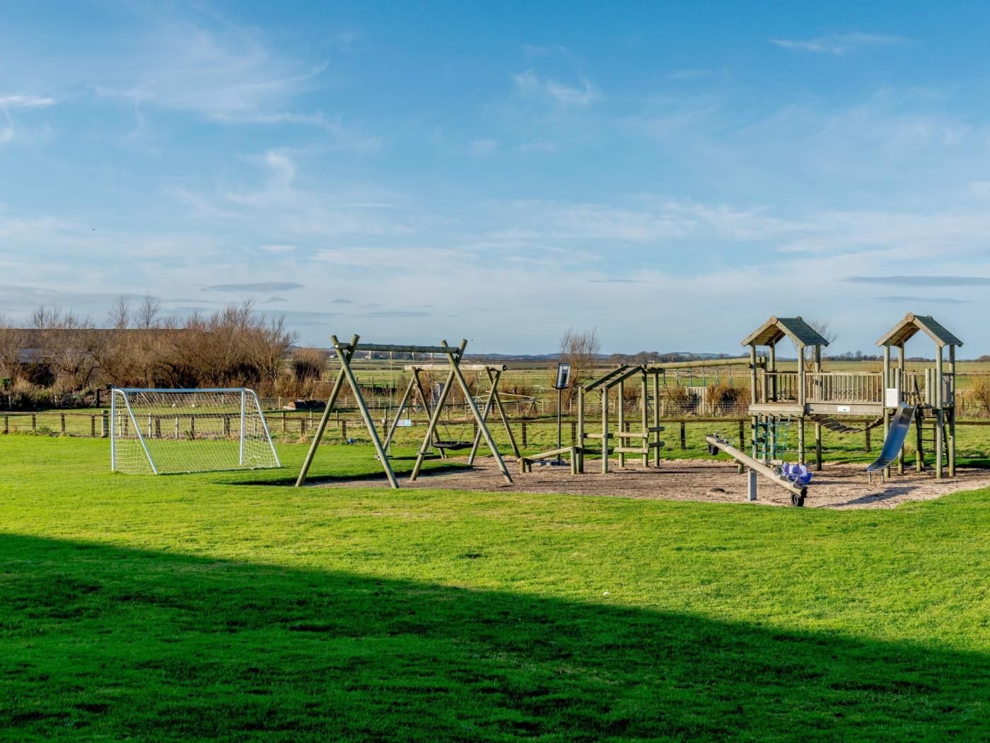 A playground with swings, a slide, and a climbing structure.