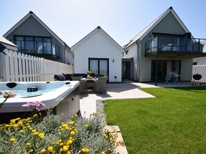 A modern house with a hot tub, outdoor seating, and a well-maintained lawn. - 4 Bed in Bideford (oc-72587) (Northam)