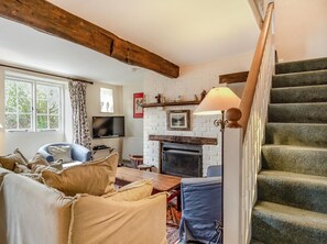 A living room with a fireplace, a staircase, and a television. - 3 Bed in Stiffkey (oc-ncc49) (Stiffkey)