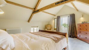 A bedroom with a sloped ceiling, a bed, a dresser, a chair, and a window with curtains. - 1 Bed in Stillington (oc-g0057) (Marton-in-the-Forest)
