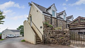 A residential property with a stone wall, a beige exterior, and a staircase leading to a second floor. - 2 Bed in Cosheston (oc-fb059) (Cosheston)