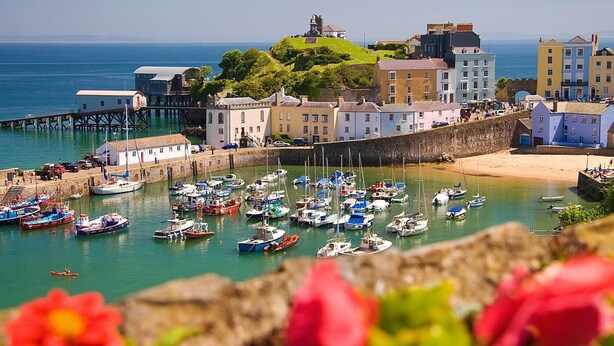 A coastal town with a harbor filled with boats, a lighthouse, and colorful buildings. - 2 Bed in Cosheston (oc-fb059) (Cosheston)