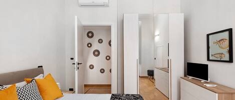 A modern bedroom with a bed, bedside table, and a wardrobe.