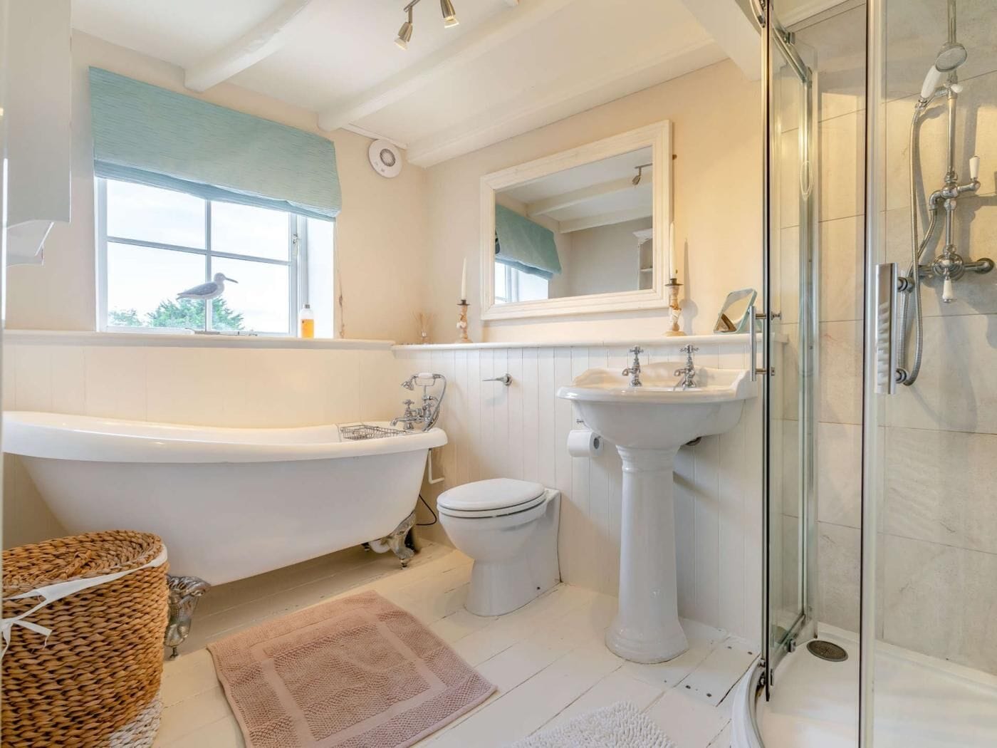Ein Badezimmer mit freistehender Badewanne, einem Standwaschbecken, einer Toilette und einer Duschkabine.