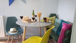 Un espace repas comprenant une table ronde, des chaises et une variété d’aliments et de boissons.