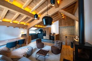 Un interior acogedor con techo de madera, comedor, cocina y chimenea.