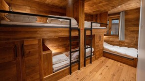 Een houten chalet met stapelbedden en een raam.