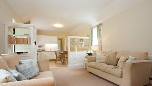 A living room with a beige sofa, a coffee table, and a bookshelf. - 2 Bed in Howden (oc-g0104) (Saltmarshe)