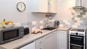 Una cucina moderna con forno a microonde, tostapane, lavello e forno.
