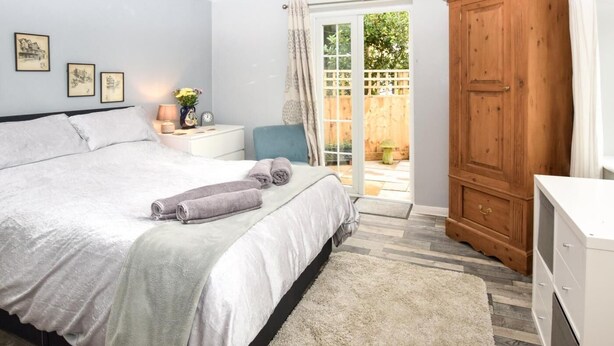 Una camera da letto con un letto, un comodino, una lampada e vista all'esterno.