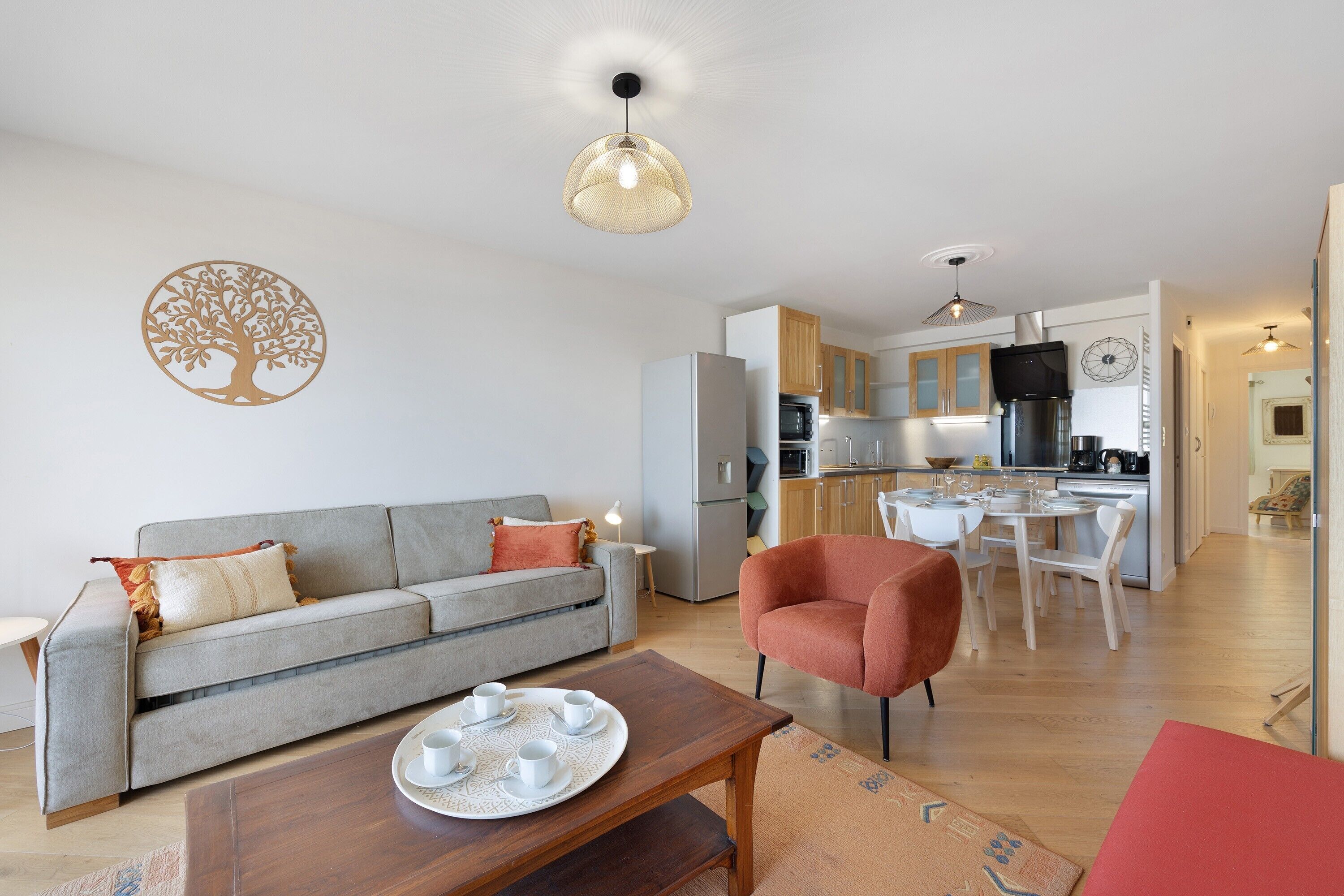 Un salon moderne avec un canapé gris, un fauteuil rouge et une table basse en bois.