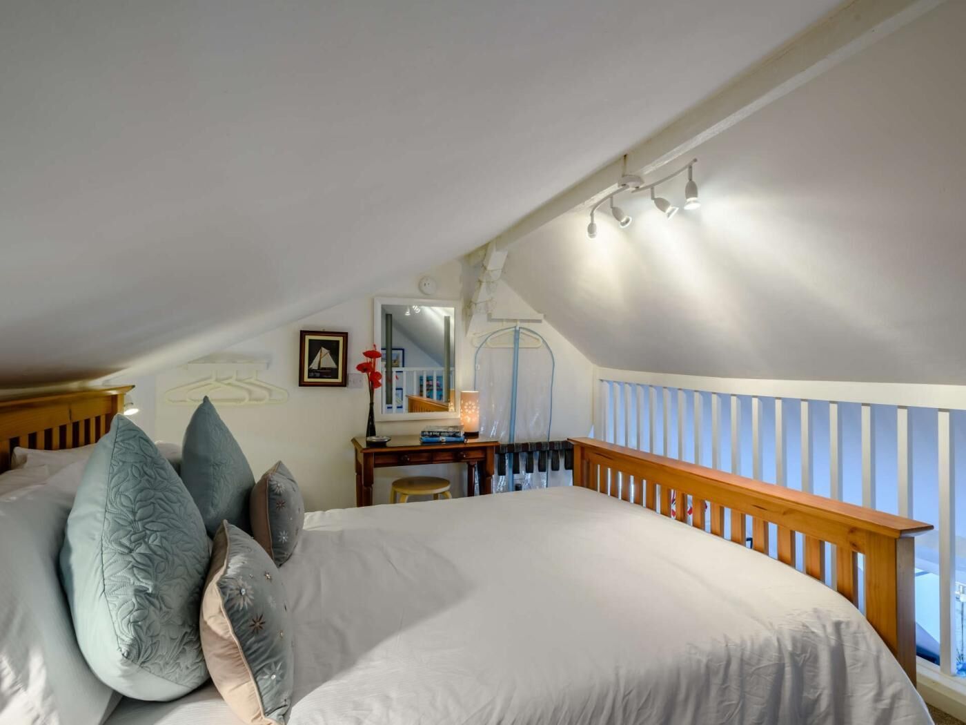 Une chambre avec un grand lit, un bureau doté d’un miroir et une fenêtre donnant sur un beau paysage.