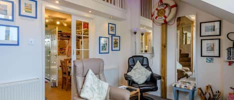 A spacious living area with a high ceiling, a loft bedroom, and a visible staircase.