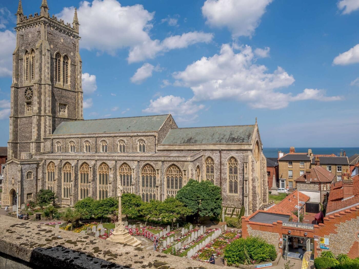A historic church with a tall tower and a cemetery with headstones.