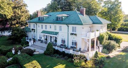 Third floor dormer style room with queen bed, reading nook, private bath with shower, and property views, located in the Belvedere Estate in Saugatuck