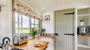 A kitchen with a wooden countertop, a kettle, a toaster, a sink, and a microwave. - 1 Bed in Market Rasen (oc-83846) (Faldingworth)