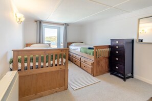 A bedroom with a wooden bed, a dresser, and a window with curtains. - 3 Bed in Polruan (oc-83821) (Fowey)