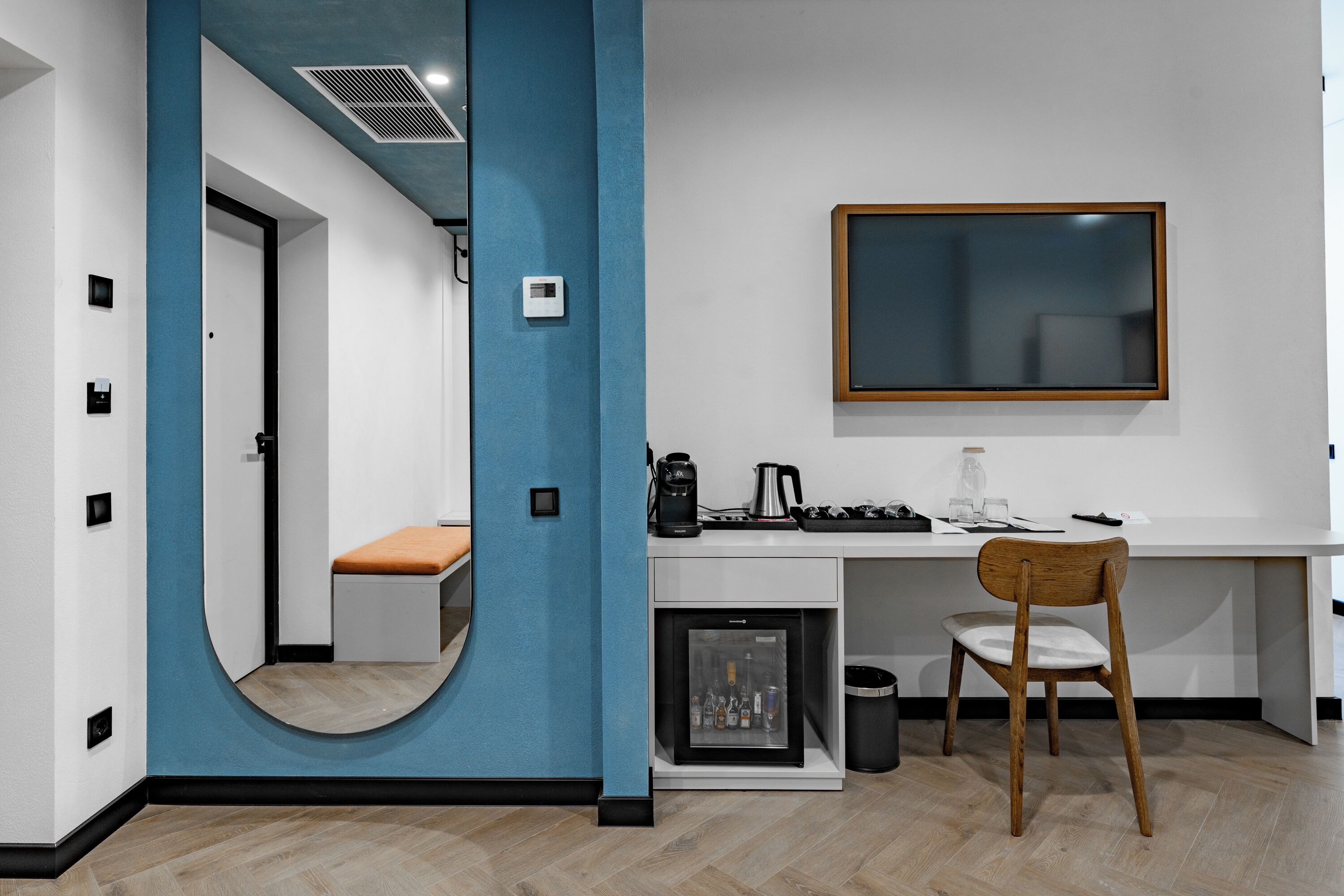 A modern kitchen with a built-in refrigerator, a coffee machine, and a wooden chair.