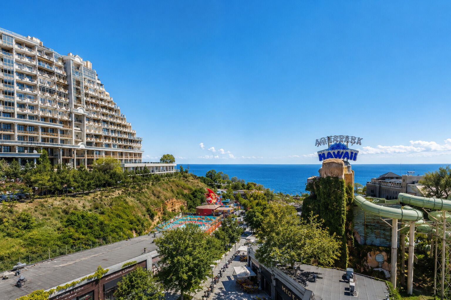 Een kustresort met een groot hotel, een waterpark en uitzicht op de oceaan.
