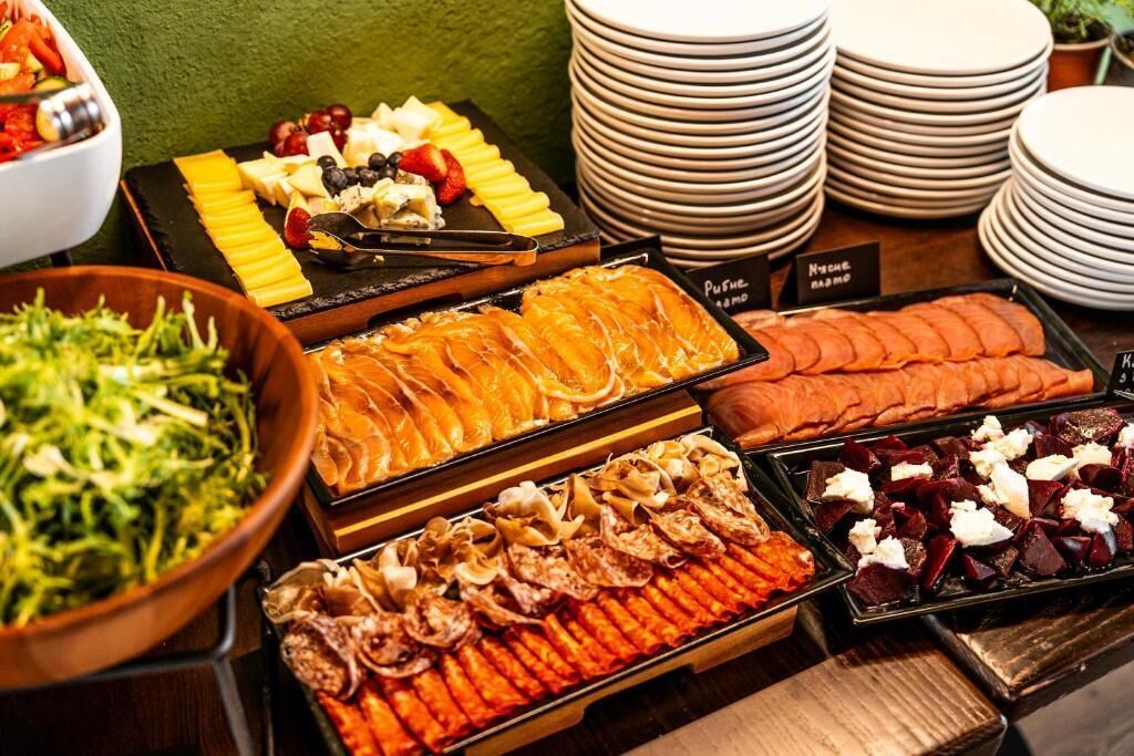 A buffet with various food items including fruits, cheeses, and meats.