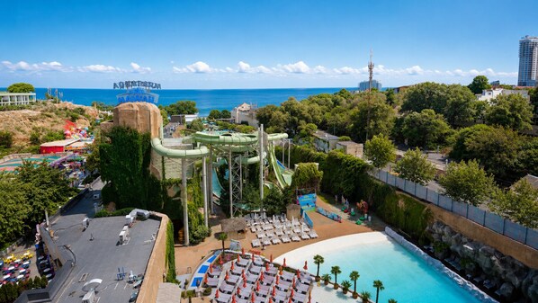 A water park with a large pool, slides, and a view of the ocean. - Spatium Medical & Wellness Hotel (Odesa)