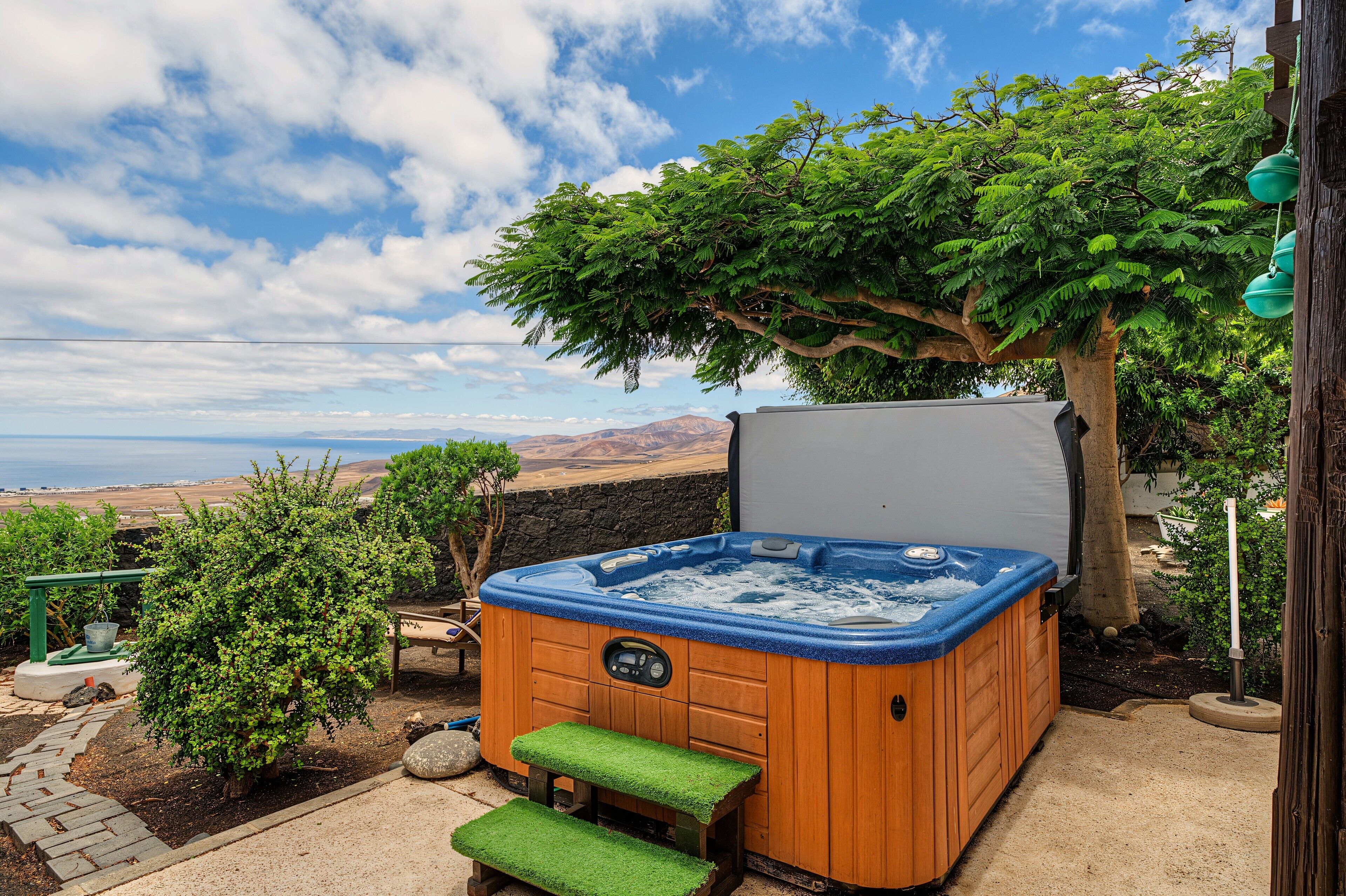 A hot tub with a wooden exterior and a view of the ocean.