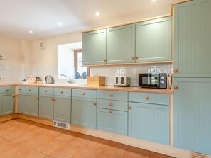 A kitchen with light blue cabinets, a wooden countertop, and a tiled floor. - 3 Bed in Bridport (oc-dc049) (Chideock)